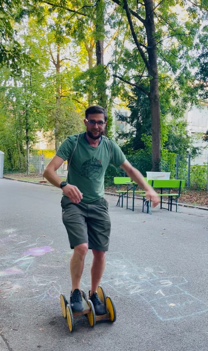 Mann auf Spielgerät (Tretroller)