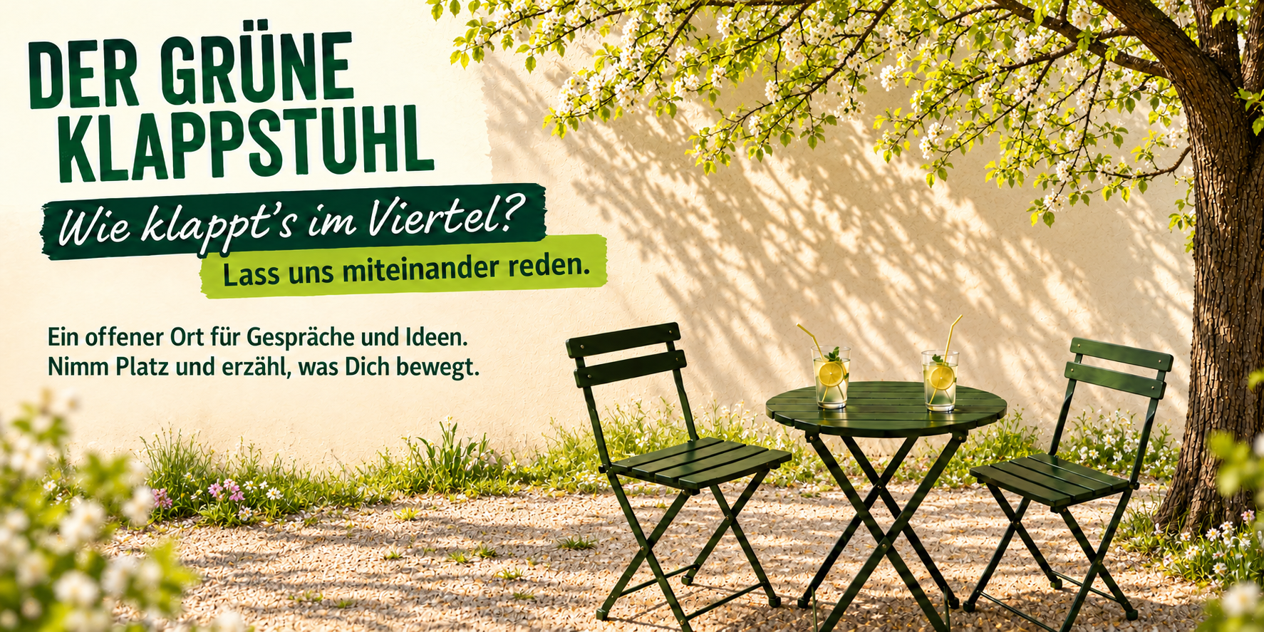 Der Grüne Klappstuhl im Frühling: Zwei Klappstühle und ein Tisch unter einem blühenden Baum; Einladung zum Gespräch im Viertel.